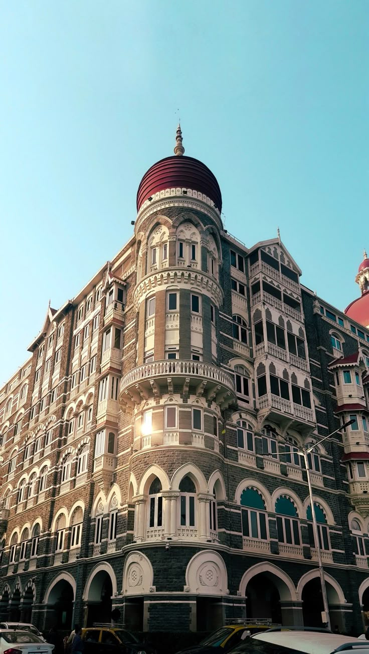 a large building with lots of windows and balconies on the top floor, in front of a blue sky