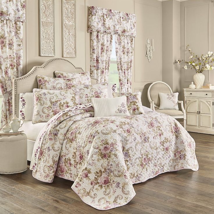 a bedroom with white furniture and flowers on the bedspread, curtains, and windows