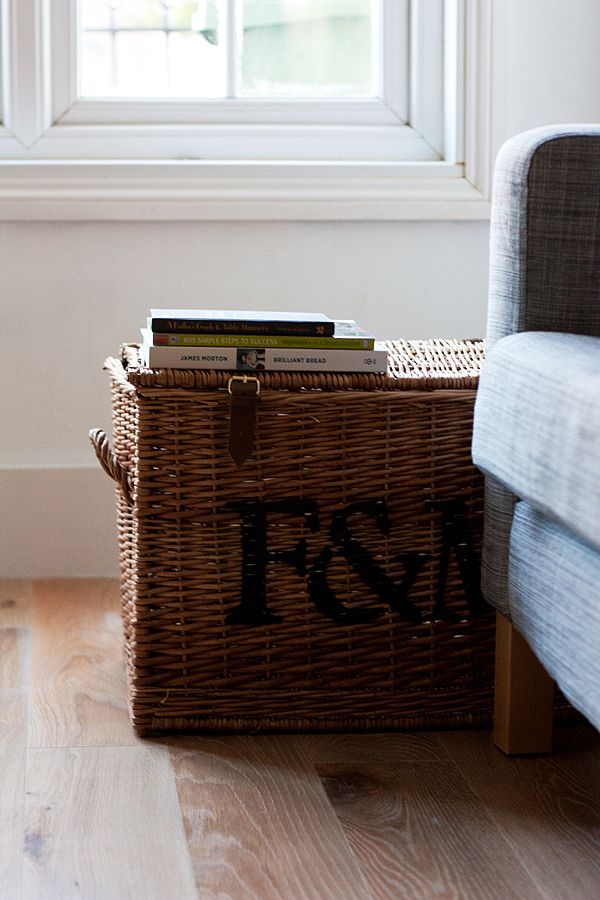 a wicker basket sitting on top of a hard wood floor next to a window