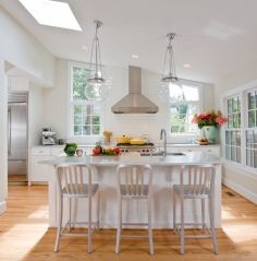 a kitchen with three chairs and a center island in the middle, surrounded by windows