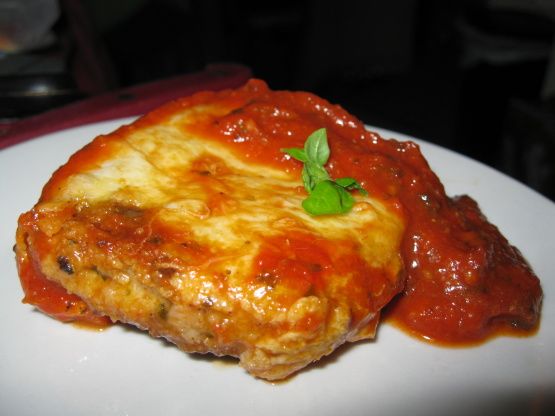 a white plate topped with lasagna covered in marinara sauce and meatballs