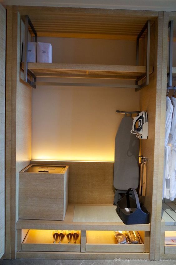 an open closet with shoes and other items in the area that is well lit up