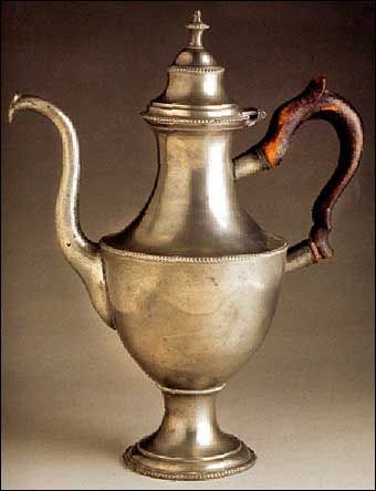 an antique silver tea pot with a handle