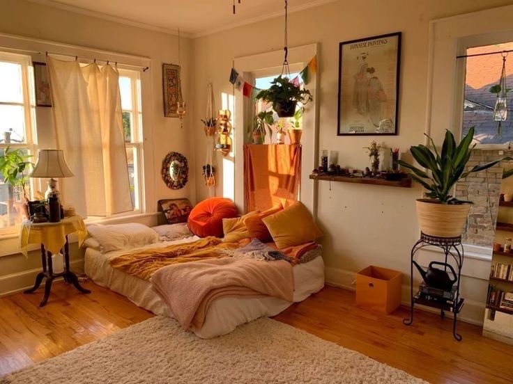 a bed room with a neatly made bed and lots of plants on the windowsill