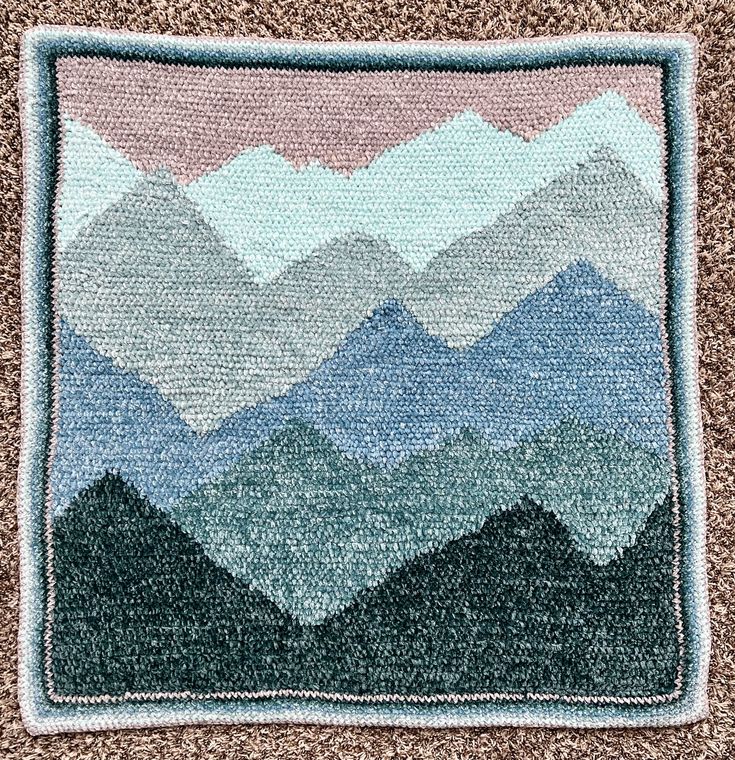 a close up of a rug with mountains on it