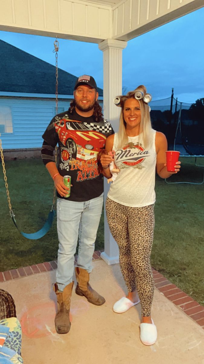 a man and woman standing on a porch holding drinks in front of the camera,