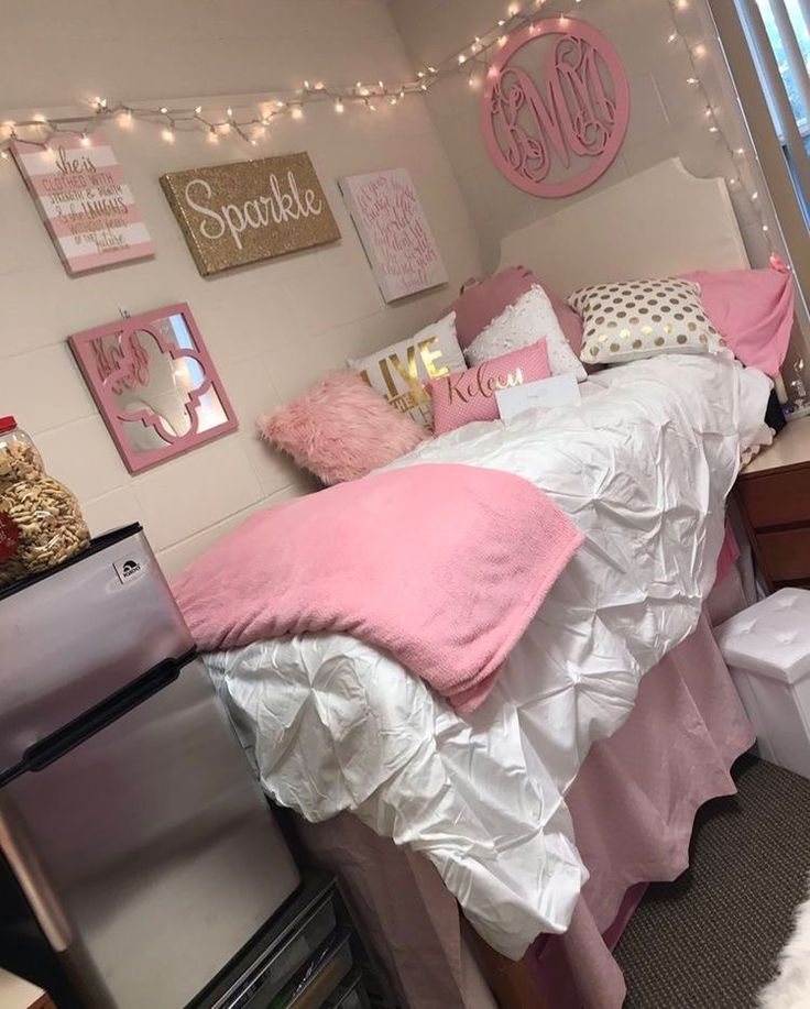 a bedroom decorated in pink and white with lots of lights on the wall above the bed