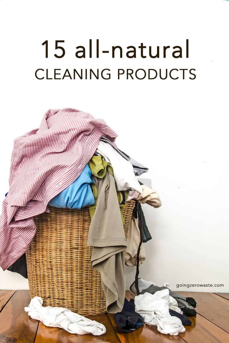 a basket full of clothes sitting on top of a wooden floor next to a white wall