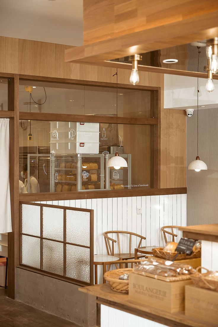 the interior of a restaurant with wood paneling and white walls, along with wooden chairs