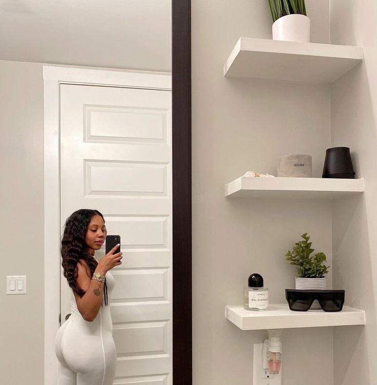 a pregnant woman taking a selfie in front of a mirror with her cell phone