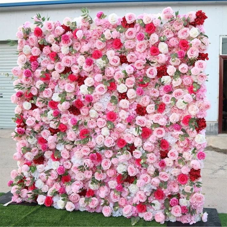 a large pink and red flowered wall in front of a building