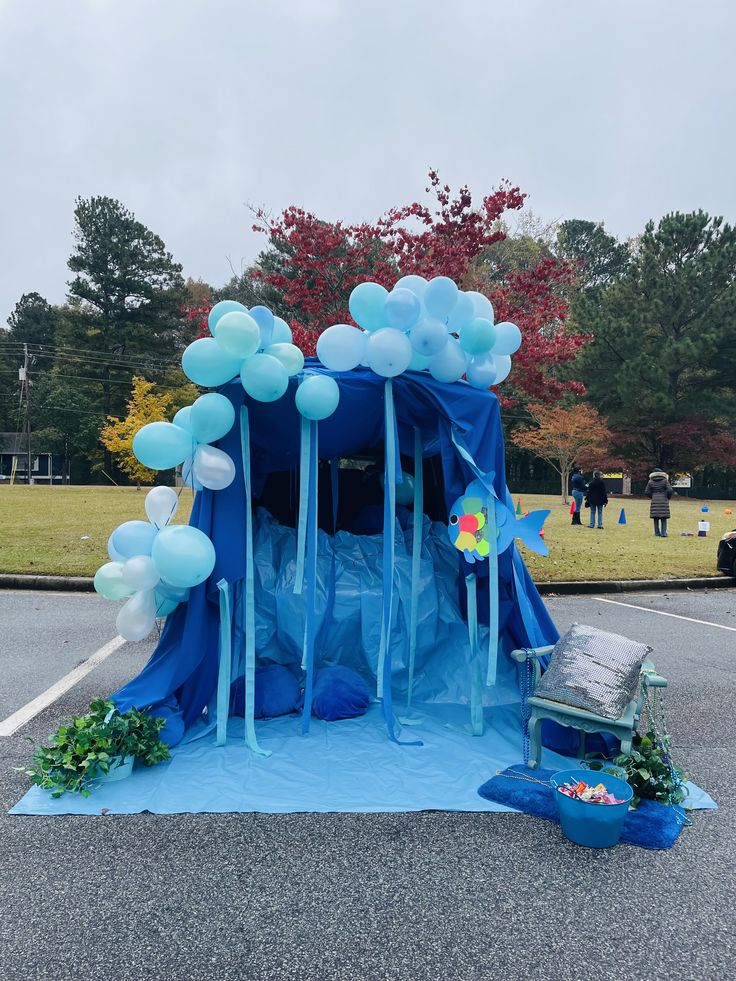 a blue tent with balloons on the ground