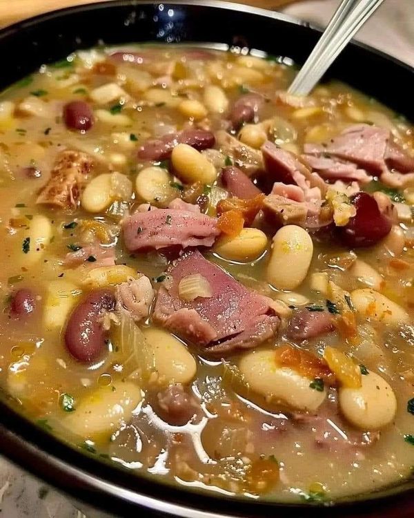 a bowl of soup with ham and beans