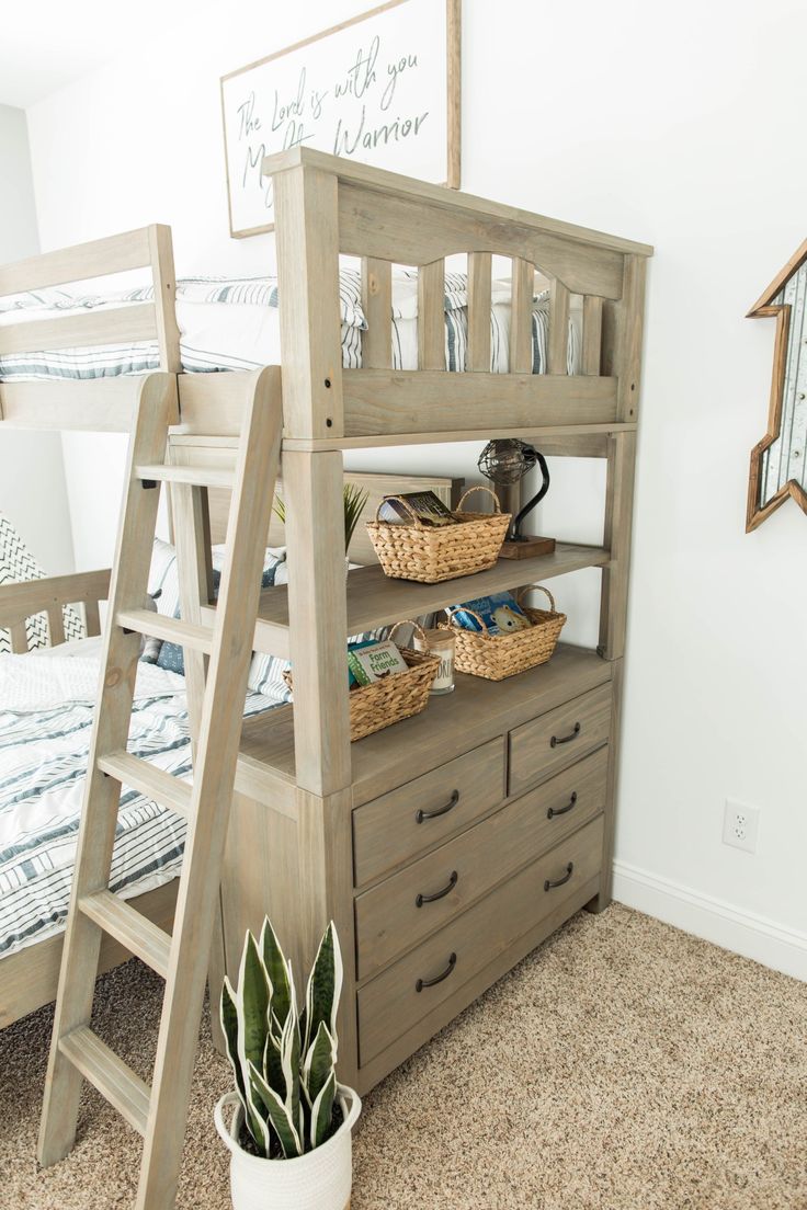 a wooden bunk bed sitting next to a dresser with baskets on top of it and a ladder leaning against the wall