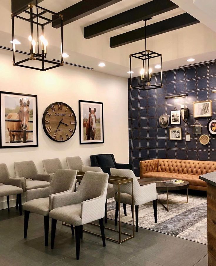 a waiting area with chairs, couches and clocks on the wall above them in an office