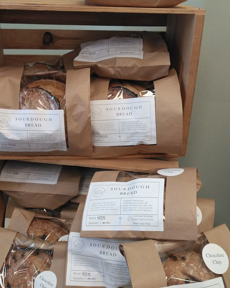 breads and pastries are stacked on top of each other in brown paper bags