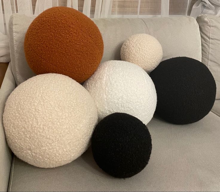 four different colored balls sitting on the back of a couch