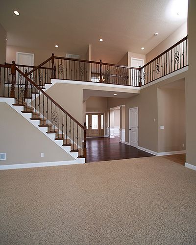 an empty living room with stairs leading up to the second floor