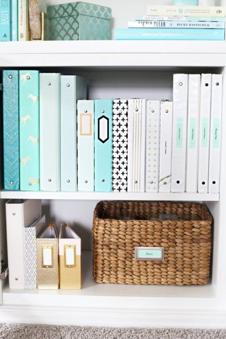 a bookshelf filled with lots of books next to a basket and other items