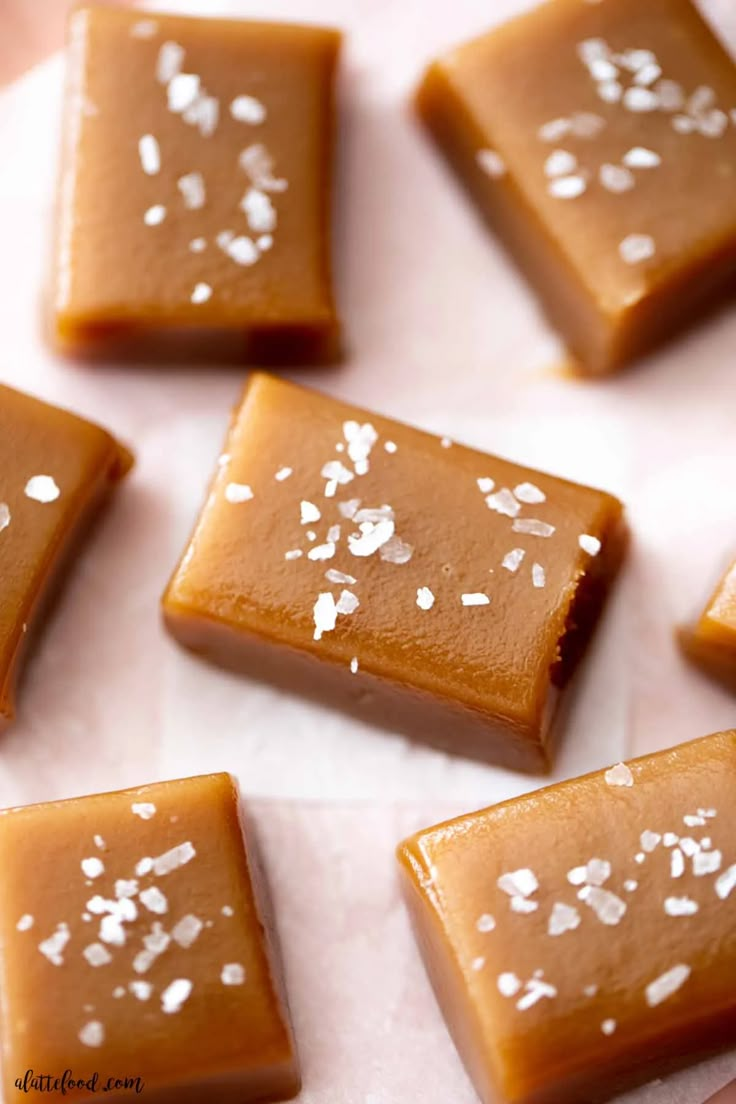 several pieces of caramel fudge sitting on top of white paper