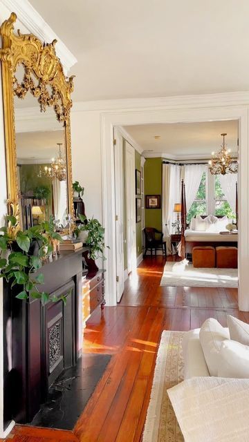 a living room filled with furniture and a fire place next to a mirror on the wall