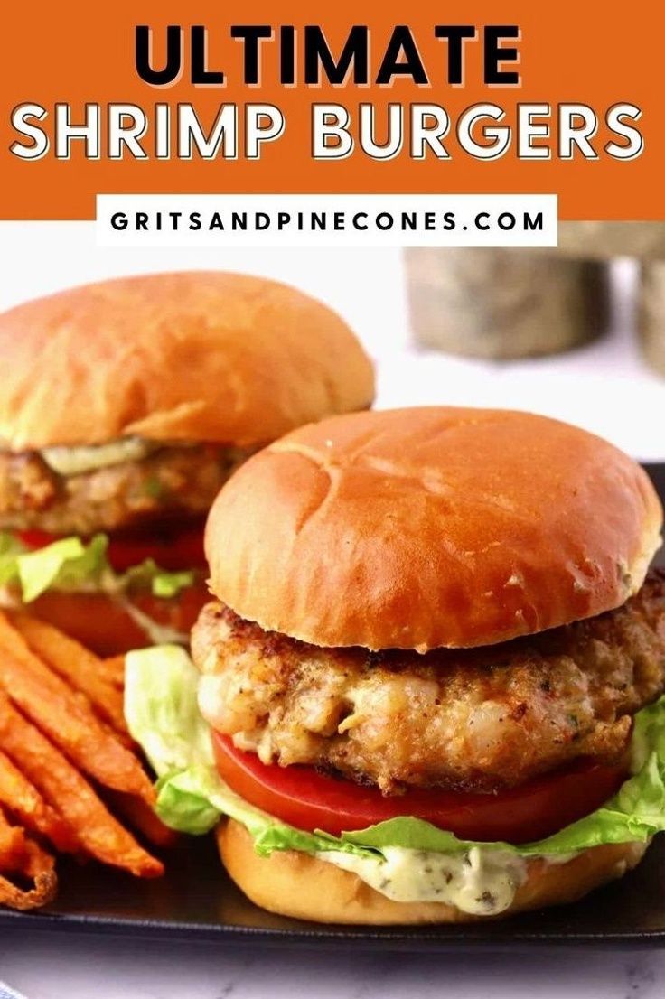 two chicken burgers with lettuce and tomato on a plate next to sweet potato fries