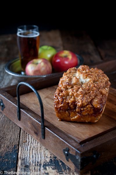 a muffin on a cutting board next to some apples