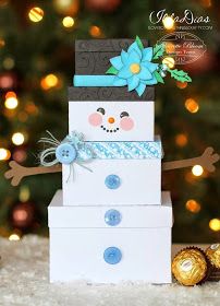 a snowman made out of boxes sitting in front of a christmas tree with candy