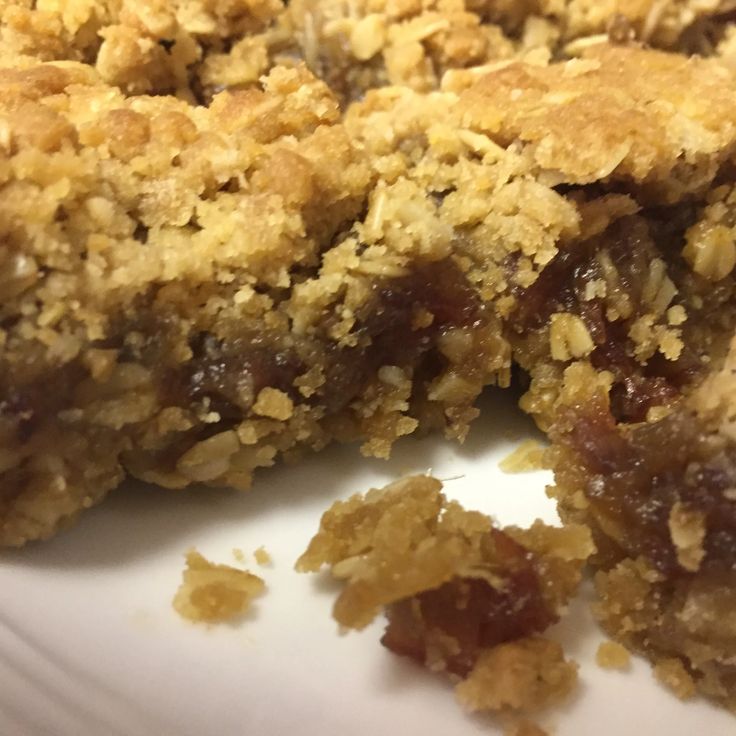 a close up of a piece of food on a plate with crumbled toppings