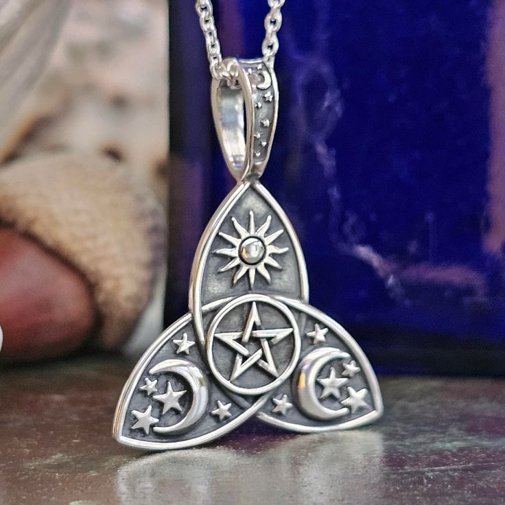 Step into the realm of celestial wonder with our exquisite Celestial Sun Moon Star Pentacle Pendant adorned with the Triquetra Symbol. Crafted from 925 Silver, this pendant captures the essence of cosmic magic. Inspired by the captivating ritual of "Drawing down the Moon," central to many contemporary Wiccan traditions, this pendant embodies the mystical connection between the earthly and the divine. As the High Priestess enters a trance to channel the Goddess, symbolized by the Moon, the pendant serves as a tangible representation of this sacred union. Beyond its enchanting symbolism, the design of the pendant is a testament to artisanal craftsmanship. Delicate details extend gracefully over the loop, enhancing the pendant's uniqueness and elegance. Key Features: - Pendant dimensions: 30m Mystical Silver Star Jewelry, Mystical Silver Star-shaped Jewelry, Moon Phase Spiritual Jewelry, Adjustable Celestial Engraved Jewelry, Magical Silver Jewelry With Sun And Moon Design, Magical Silver Moon Phase Jewelry, Silver Celestial Necklace 925, Silver Celestial Necklace Stamped 925, Spiritual Moon-shaped Collectible Jewelry