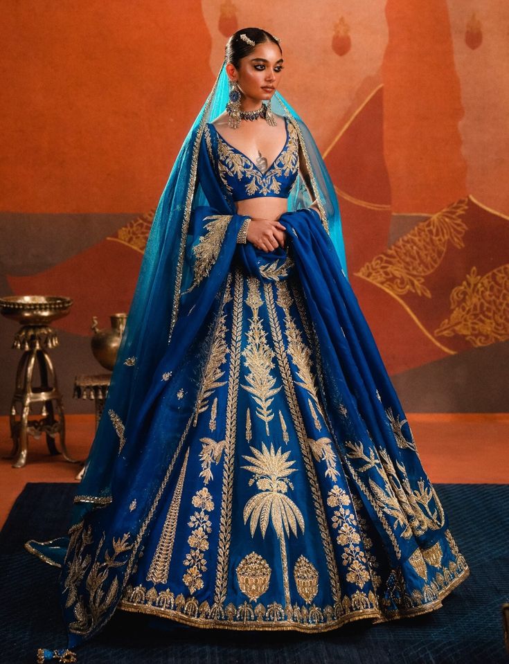 The neel bahar lehenga in brilliant azure blue sparkles at any occasion. Adorned with delicate sehra motifs that shimmer throughout, it is paired with a sleeveless embellished blouse and a long tulle dupatta. Featuring hours of artisanal handwork with zardozi, katdana, and sitara embroidery, this lehenga is a modern-day fairytale. It also includes a separate cancan. House Of Masaba, Embellished Blouse, Blue Sparkles, Azure Blue, Silk Organza, Only Fashion, Classy Women, Raw Silk, Contemporary Fashion