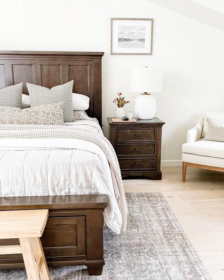 a bedroom with a bed, dresser and chair in it