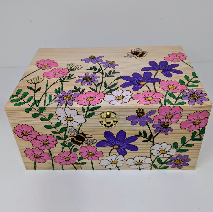 a wooden box with flowers painted on it