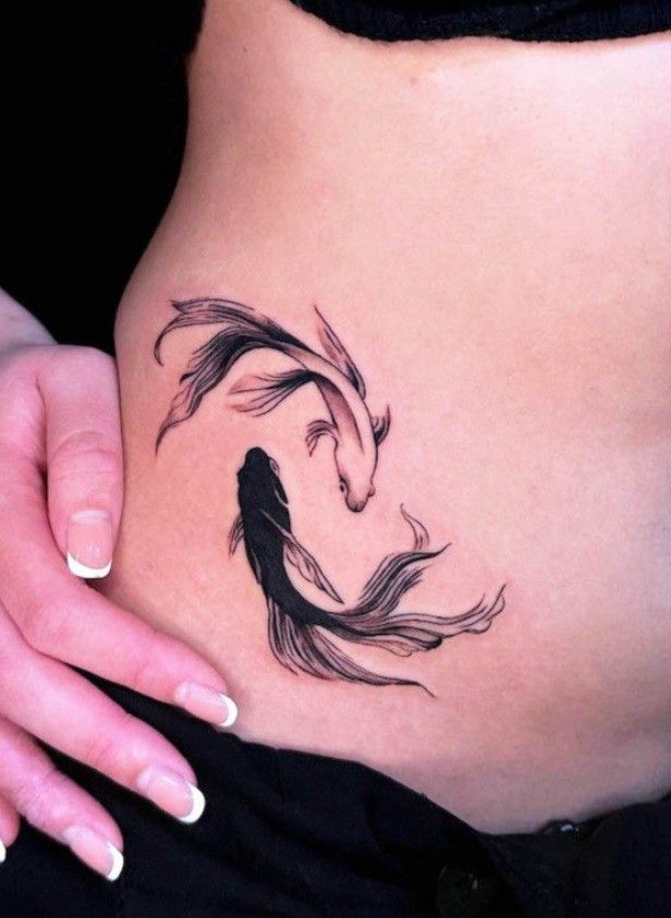 a woman's stomach with a fish tattoo on it