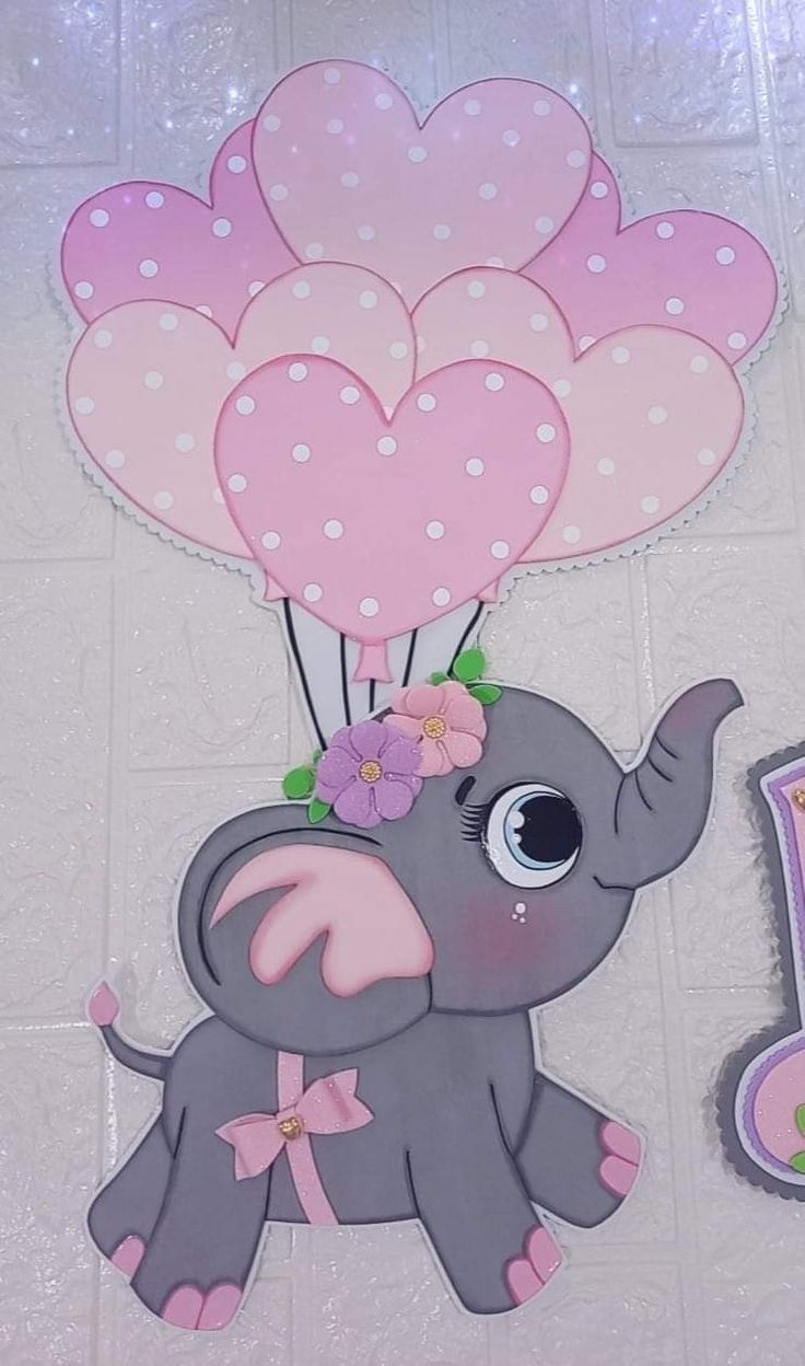 a baby elephant holding balloons on top of a tile floor