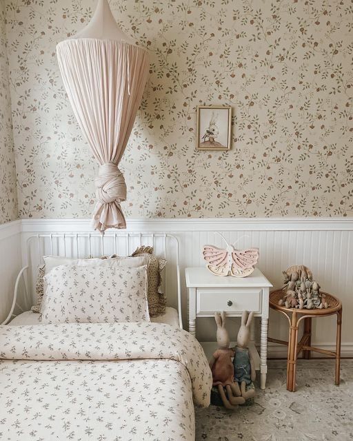 two beds in a room with floral wallpaper and white bedding on the walls