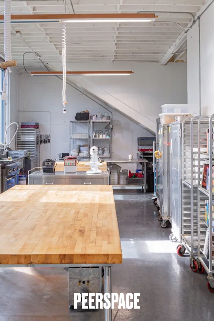 an industrial kitchen with wooden counter tops and stainless steel appliances