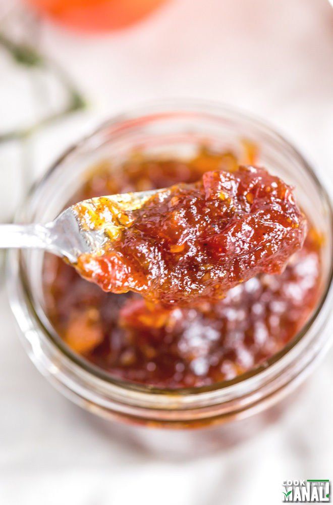 a spoon full of jam sitting on top of a table