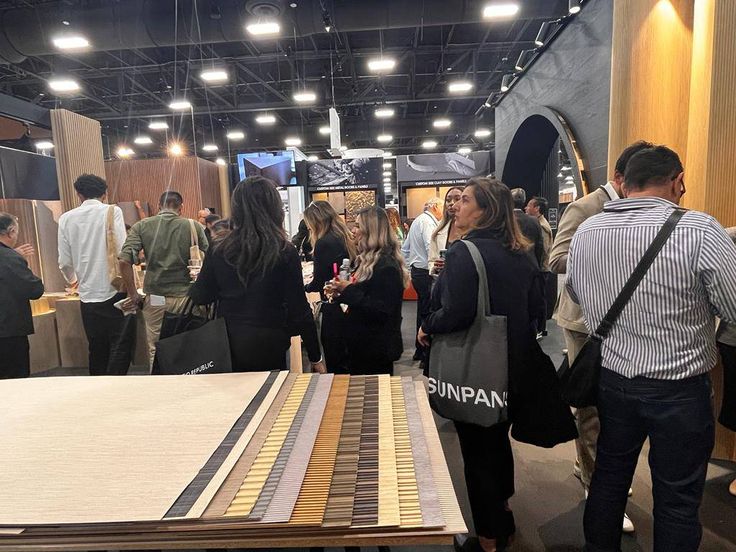 many people are standing around looking at the flooring on display in a showroom