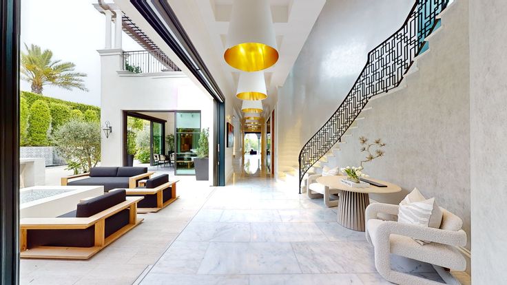 a long hallway with chairs, tables and lamps on the side walk leading up to an indoor swimming pool