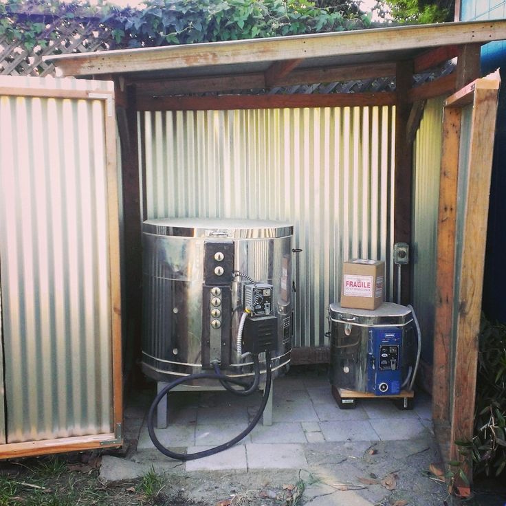 an open metal container with some equipment in it's back yard, next to a blue and white fire hydrant