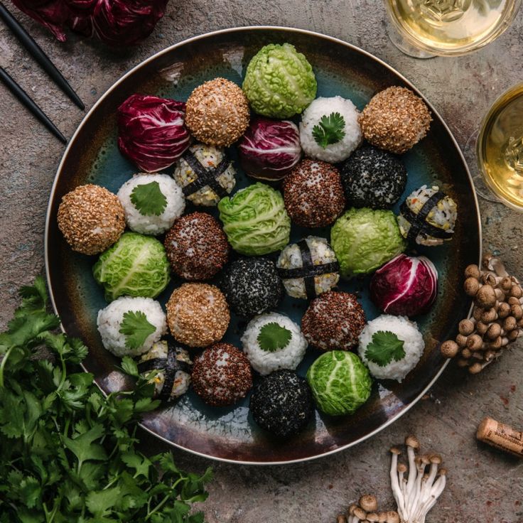 a plate full of different types of food next to some wine glasses and other items