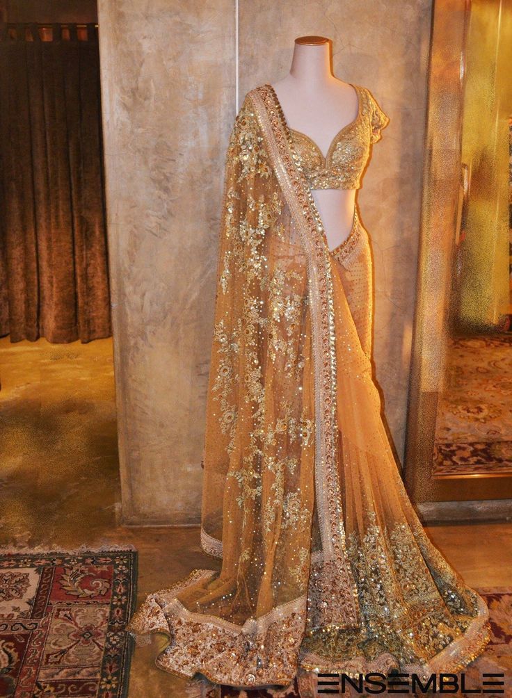 a mannequin dressed in an elaborate gold gown and shawl with sequins on it