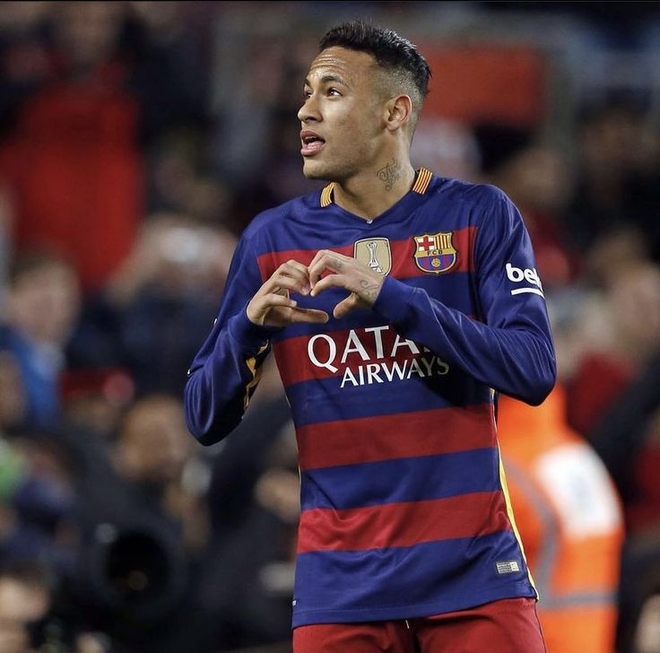 a soccer player is holding his hand out in front of him and looking at the crowd