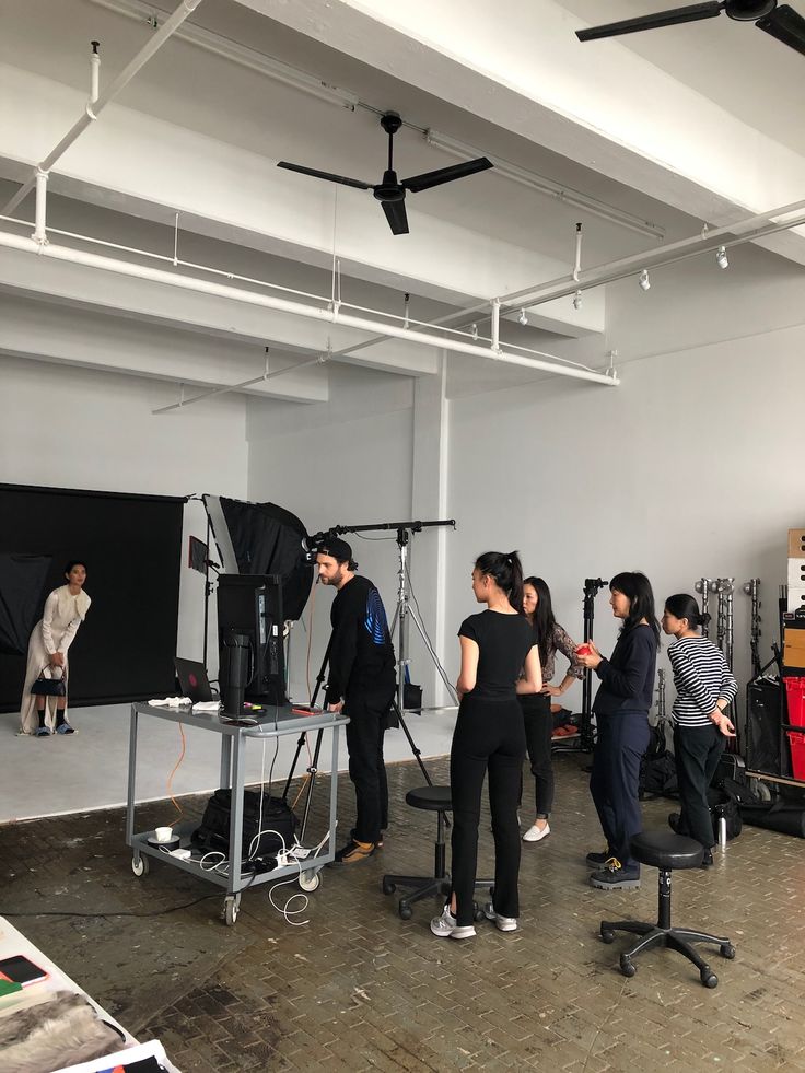 a group of people standing in front of a camera set up for a photo shoot