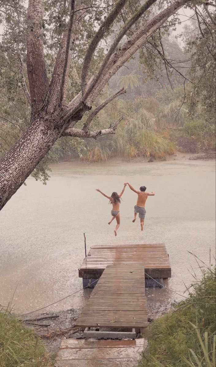 two children jumping off a dock into the water