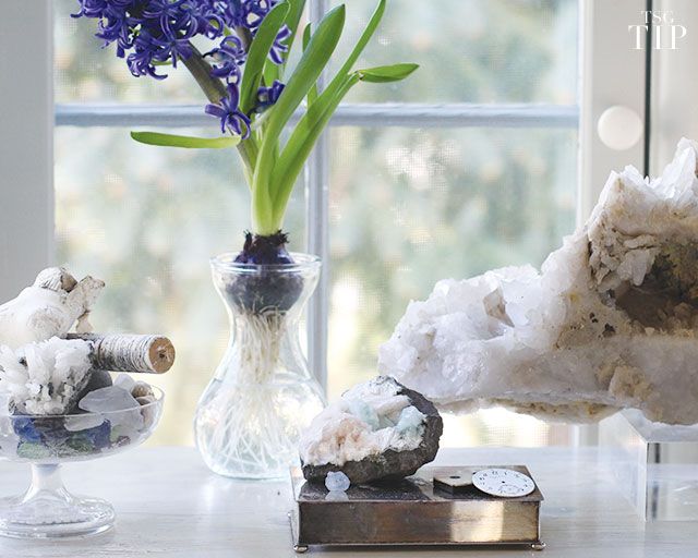 three different types of rocks and flowers in a vase on a table next to a window