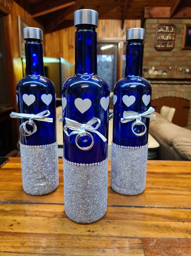 three blue glass bottles with hearts on them