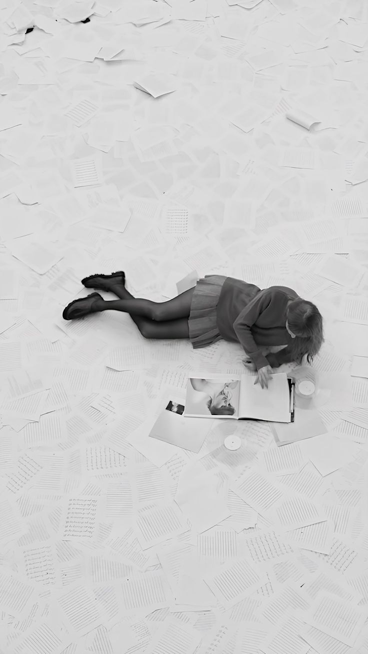 a woman laying on top of a bed covered in paper