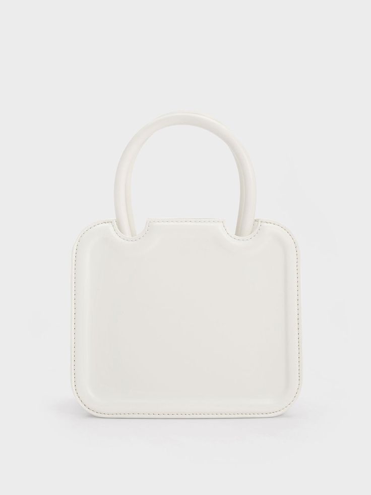 In classic white to match most outfits you can put together, the Perline sculptural tote bag is a worthy addition to your list of style staples. Featuring a square silhouette with rounded corners for a more feminine feel, the details make all the difference when it comes to this piece – the semicircle cut outs and gold-toned brand insignia add a touch of sophistication. Carry yours by the handles for a polished and sophisticated feel, or clip on the adjustable strap to create a cool and casual a Trendy White Box Bag For Daily Use, White Top Handle Box Bag With Adjustable Handle, White Shoulder Bag With Round Adjustable Handle, White Shoulder Bag With Adjustable Round Handle, Trendy White Square Box Bag, White Casual Box Bag With Adjustable Strap, Eco-friendly White Shoulder Bag With Adjustable Strap, Casual White Box Bag With Adjustable Strap, White Casual Satchel Box Bag